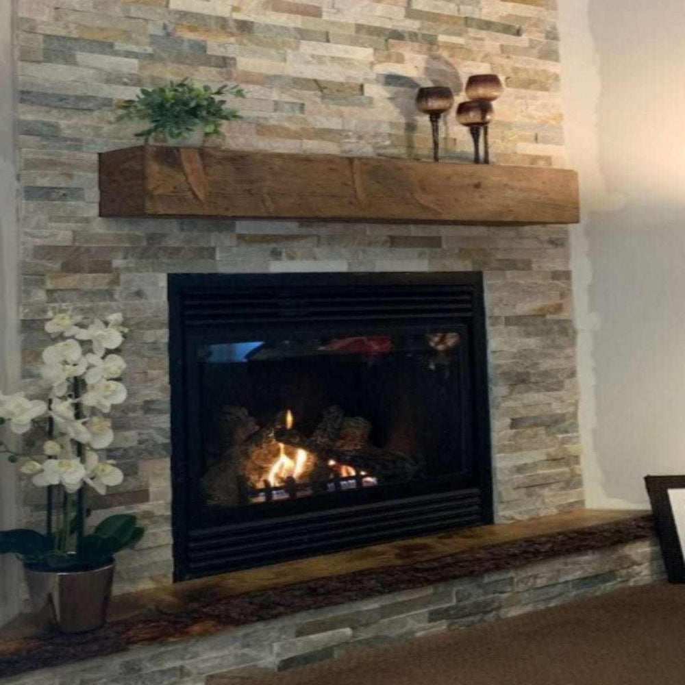 Handcrafted rustic wood fireplace mantel on stone wall with decor.