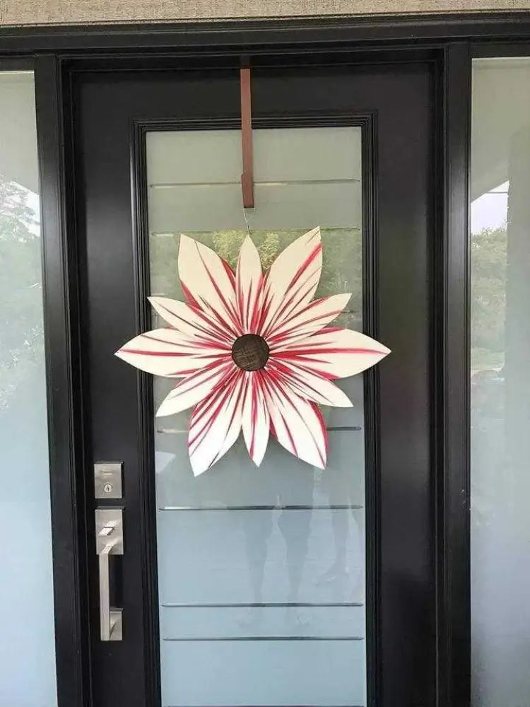 Candy Stripe Wood Flower Door Decoration in red and white candy cane colors on a glass-paneled door.