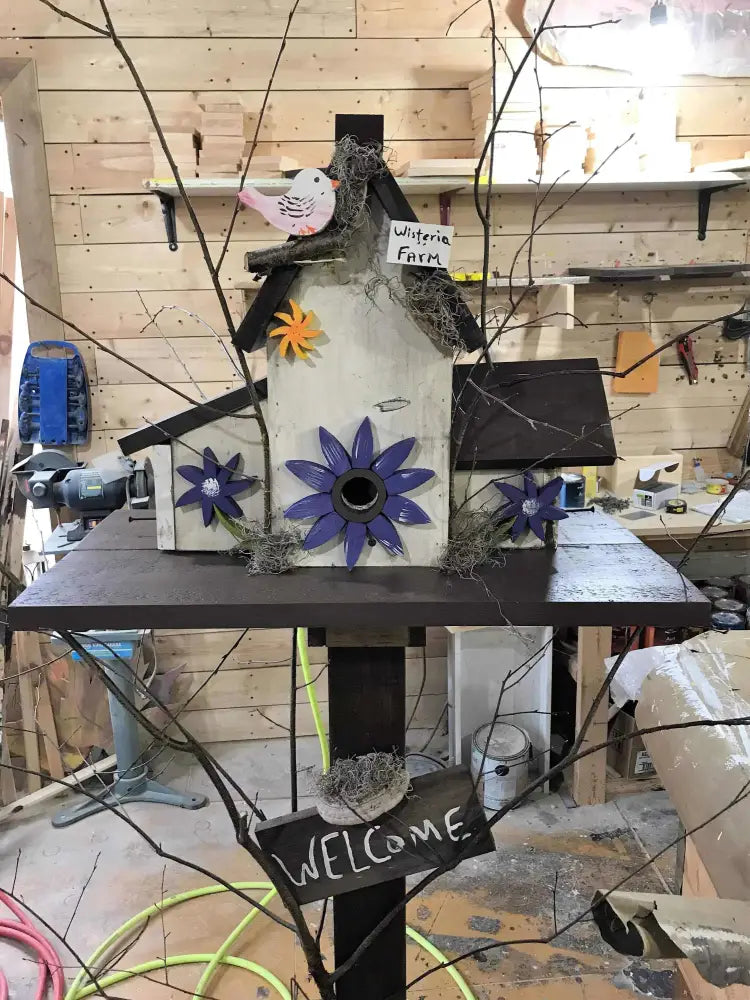 Triple birdhouse made of pine wood with decorative flowers and a "WELCOME" sign, designed for bird lovers and outdoor garden use