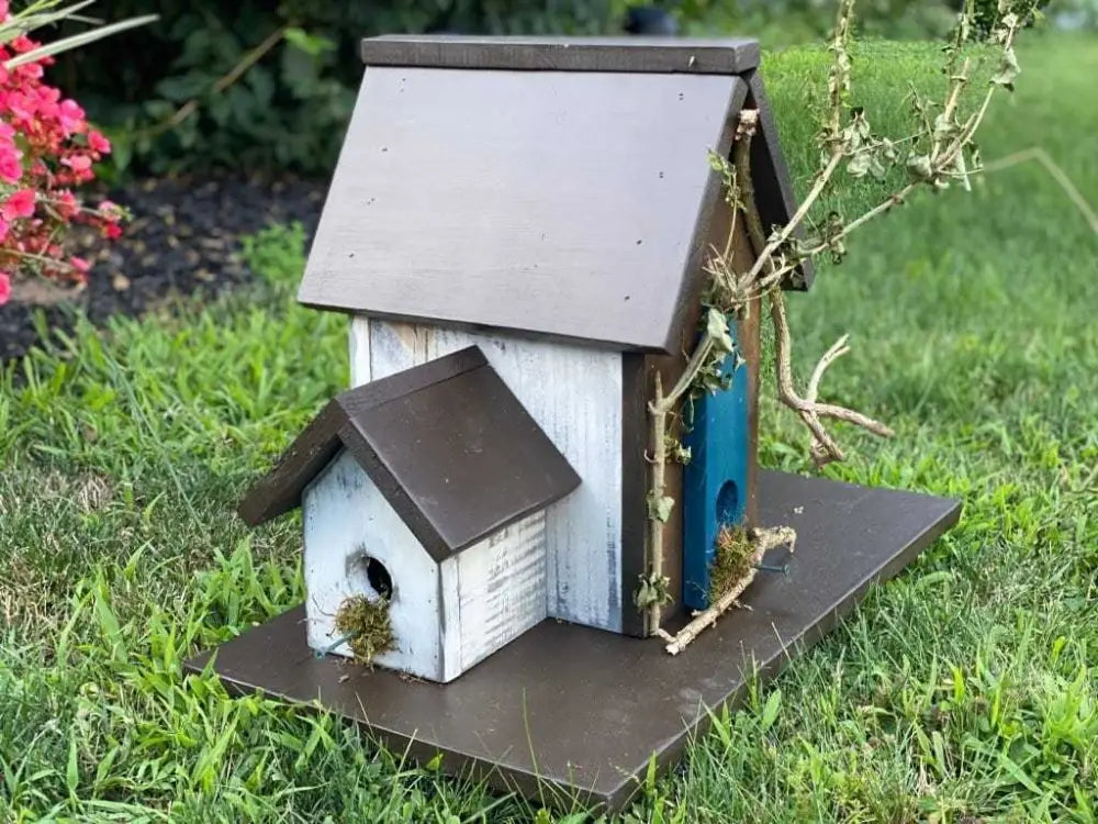 Triple birdhouse made of pine wood with three compartments, customizable and weather-resistant, in a garden setting.