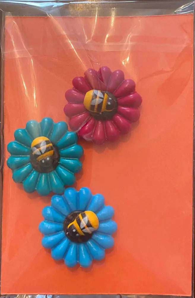 Daisy and Ladybug Bees Fridge Magnet Set in bright colors, made from polymer clay, on an orange background.