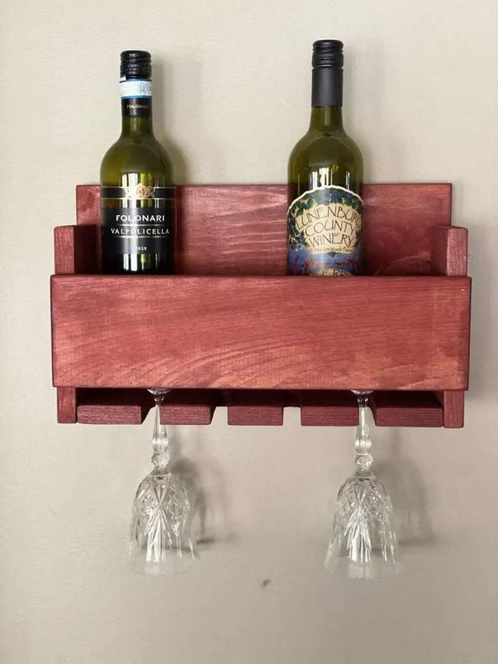 Rustic wall-mounted wine bottle and glass holder made from high-quality pine wood, holding two wine bottles and two glasses.