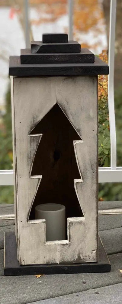 Handcrafted wooden lantern with intricate tree design, suitable for indoor or outdoor decor.