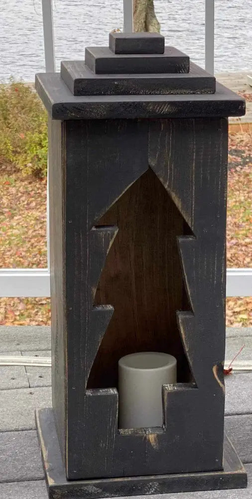 Handcrafted wooden lantern with intricate design and candle holder.