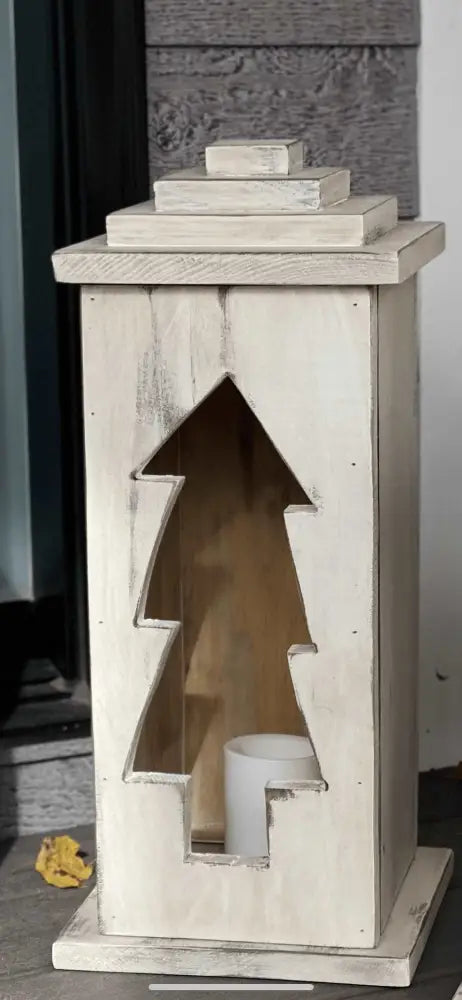 Handcrafted wooden lantern with tree design and candle for indoor or outdoor use.
