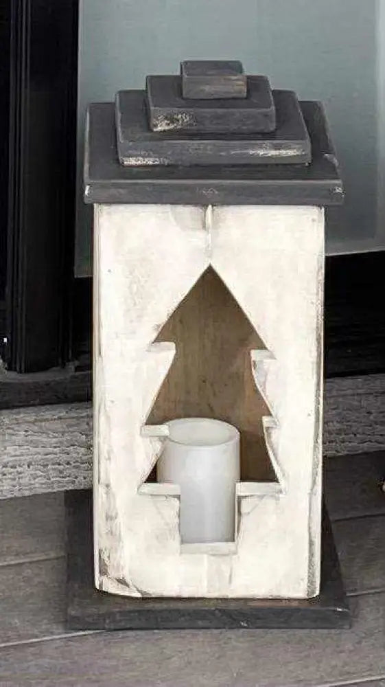 Handcrafted wooden lantern with tree cutout design.