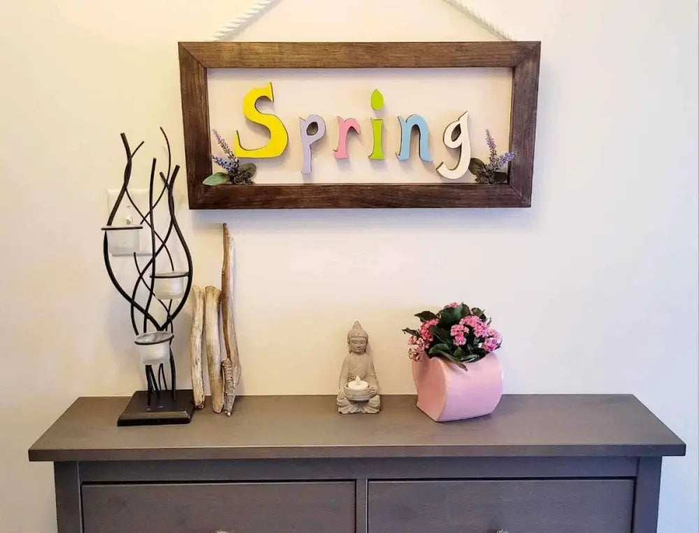 Handmade wooden sign with colorful "Spring" letters and rope for hanging, crafted from pine wood.