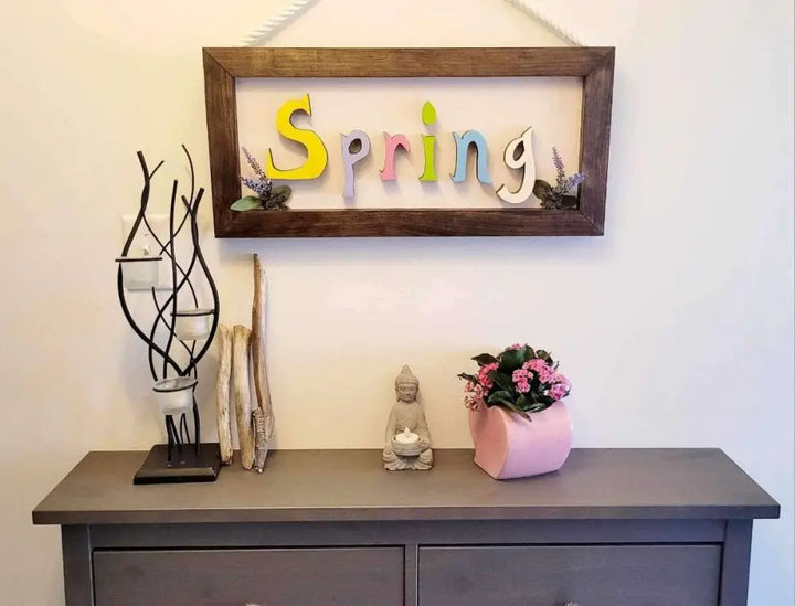Handmade wooden sign with colorful "Spring" letters and rope for hanging, crafted from pine wood.