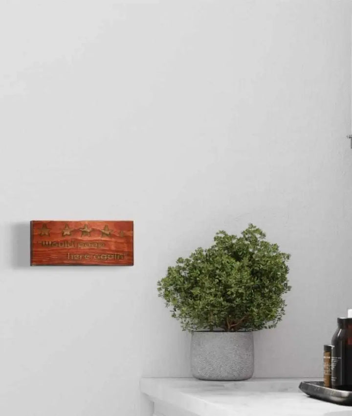 Rustic "Would Poop Here Again" bathroom sign on wall, adds humor and personality to decor.