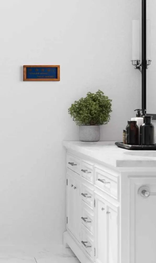 Rustic 'Would Poop Here Again' bathroom sign in modern bathroom setting.