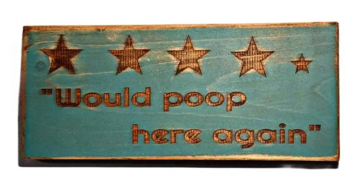 Rustic "Would Poop Here Again" bathroom sign with engraved stars and humorous slogan.