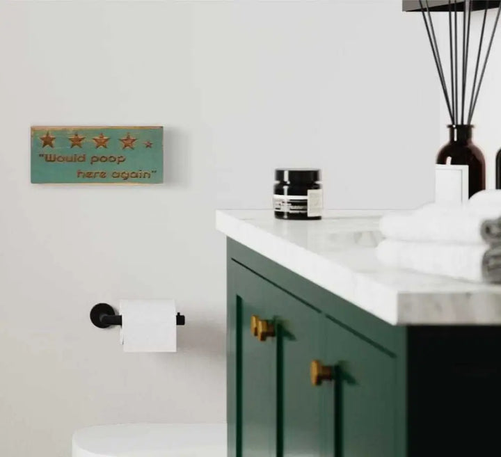 Rustic "Would Poop Here Again" bathroom sign with stars, adding humor to decor.