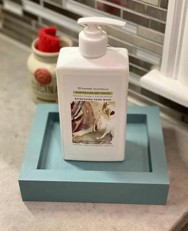 Handcrafted pine soap dish in blue with a hand wash bottle on top.