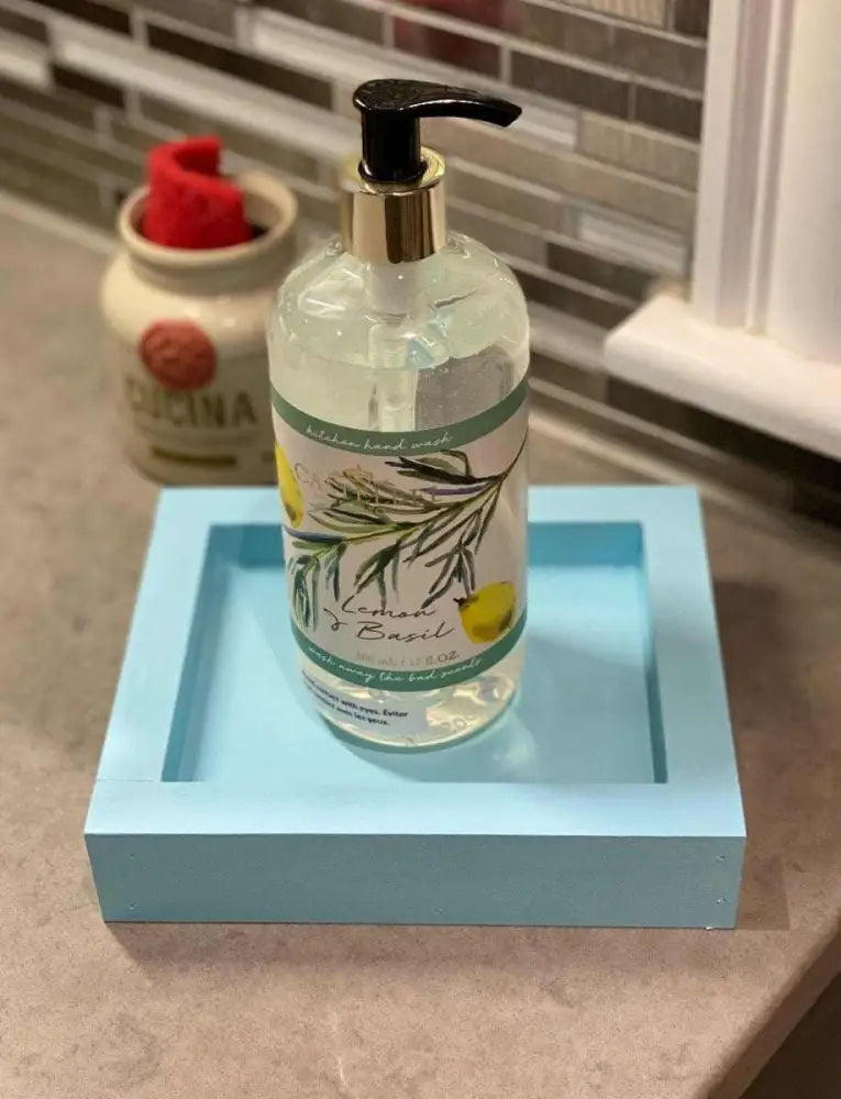 Handcrafted pine soap dish in vibrant blue with a bottle of soap, adds charm and practicality to any room.