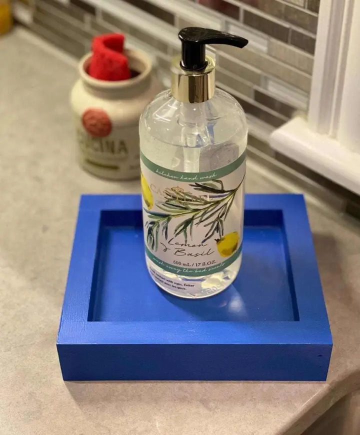 Handcrafted blue pine soap dish holding liquid soap on a bathroom counter.