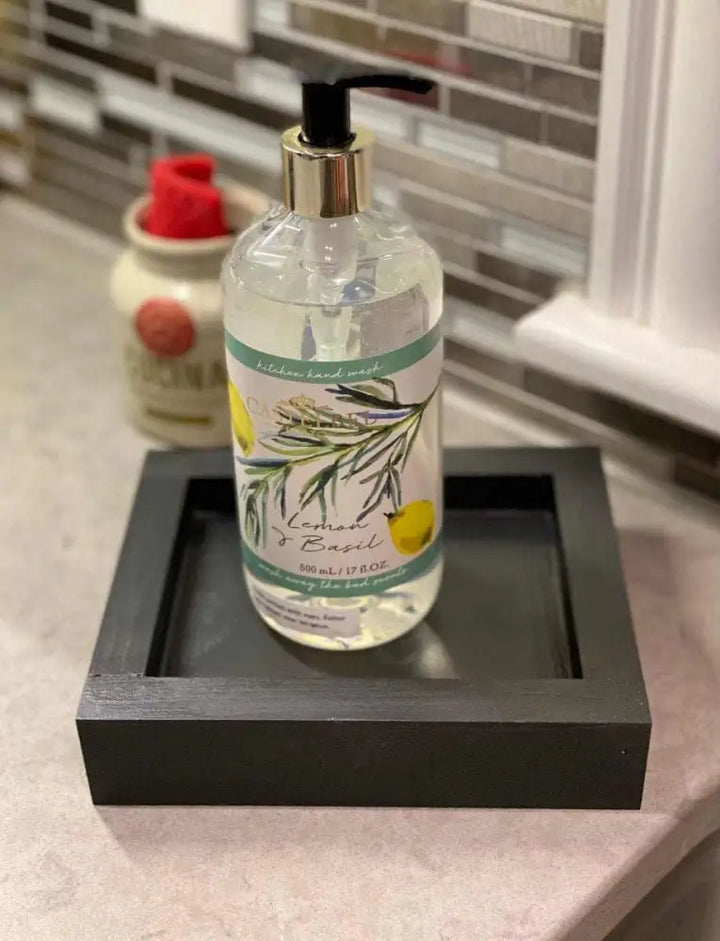 Handcrafted pine soap dish with liquid soap bottle on a bathroom counter.