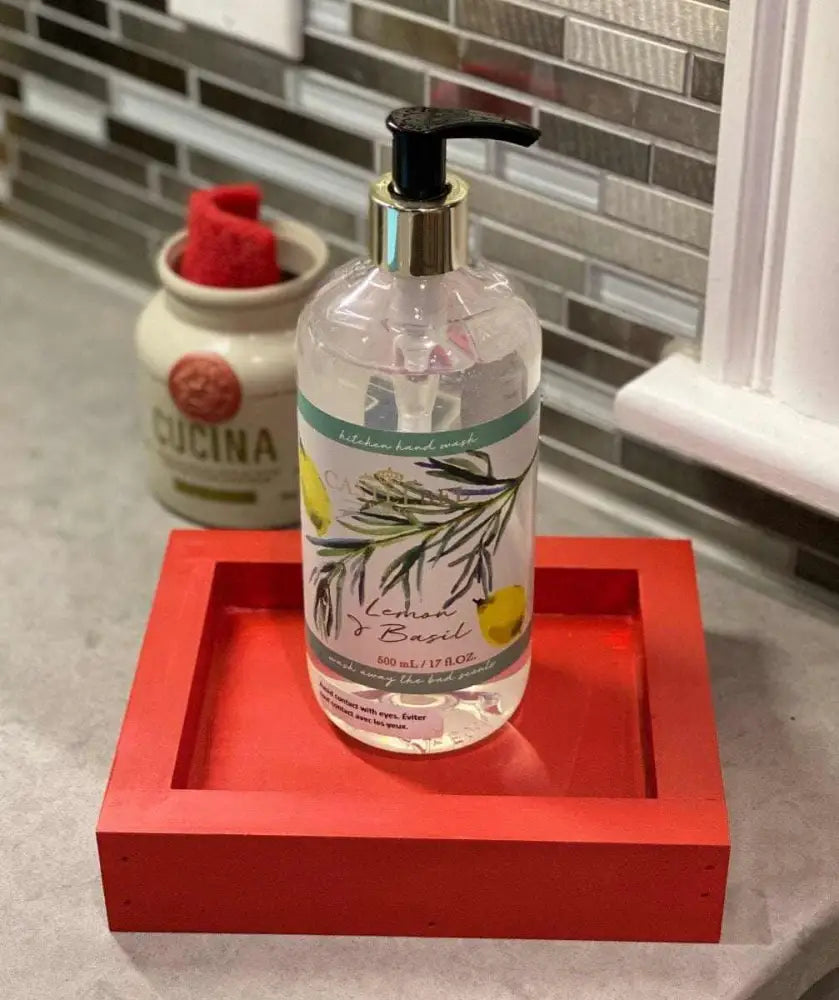 Handcrafted red pine soap dish holding a soap bottle on a countertop.