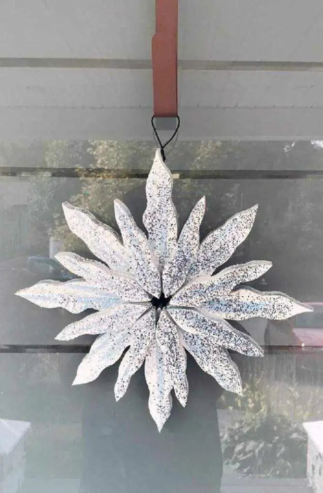 Handcrafted snowflake decoration with silver glitter, pine construction, and galvanized wire hanger.