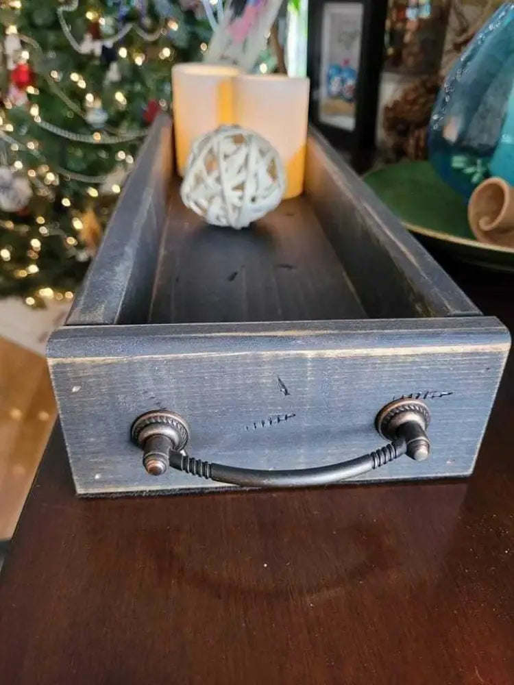 Antiqued wooden trays with handles, rectangular shape, displayed on table with decorative items.