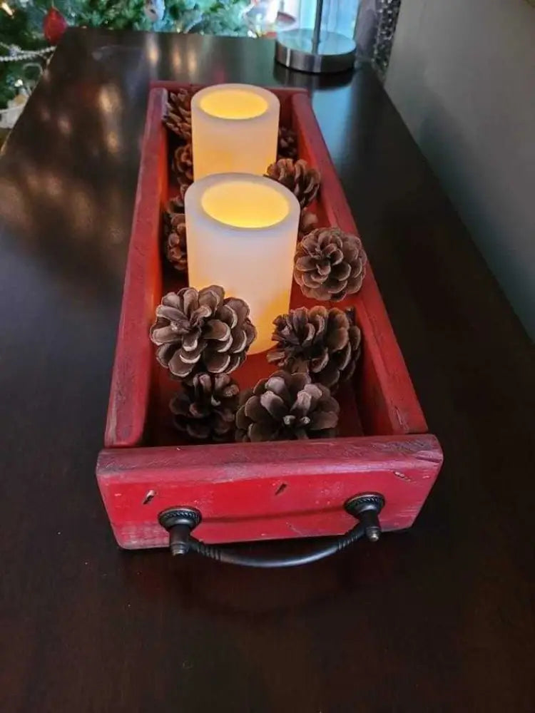 Antiqued Wooden trays with candles and pinecones, featuring handles for easy transport.