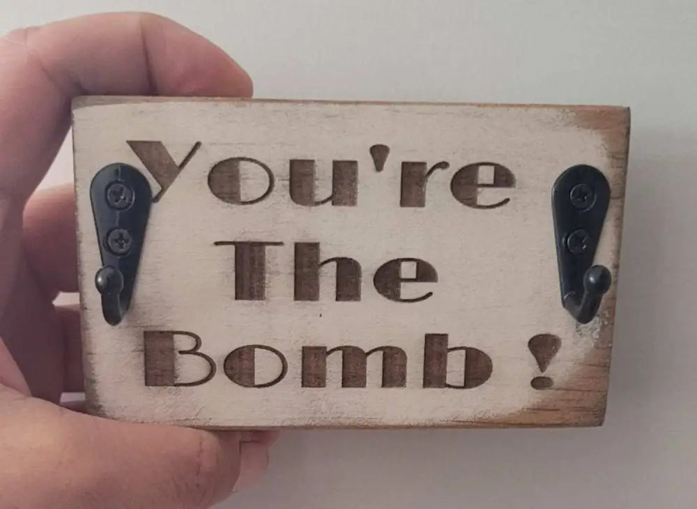 Handmade wood keychain holder with "You're The Bomb!" engraving, two hooks for easy key storage.