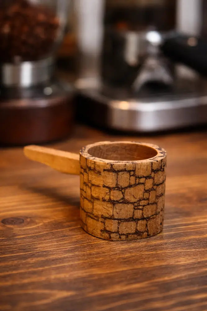 Handmade rustic wooden coffee scoop with stone-like texture and natural handle