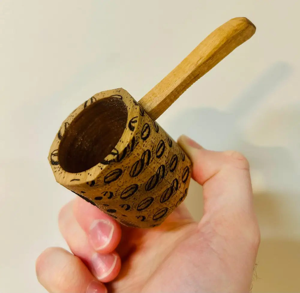 Handmade wooden coffee scoop with carved bean pattern and smooth handle