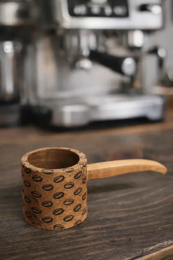 Handmade rustic wooden coffee scoop with engraved bean pattern