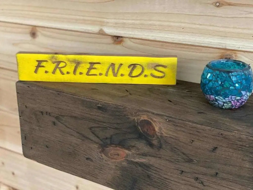 Laser engraved friendship sign on wooden shelf, ideal gift for best friend.