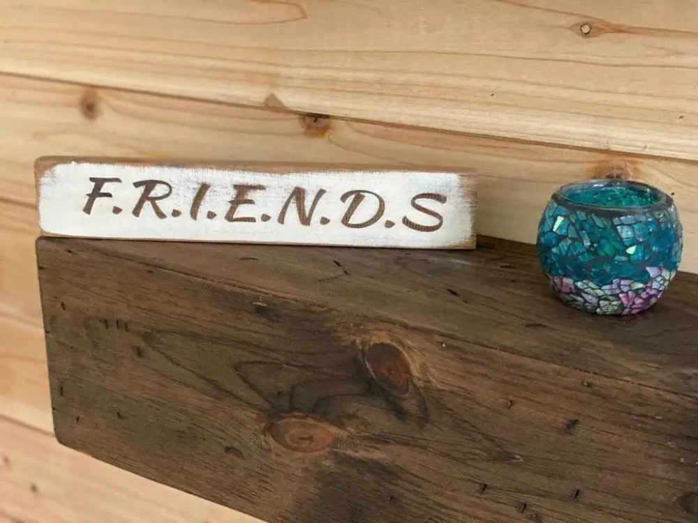 Laser engraved friendship sign on wooden shelf, perfect gift for best friends.