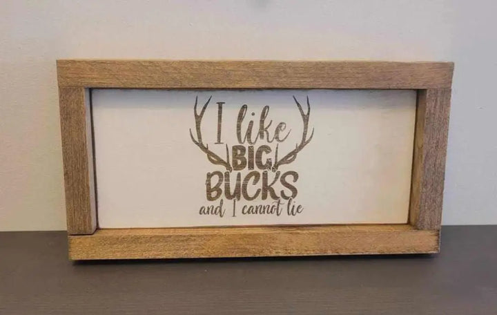 Laser engraved wood sign with antler design and "I like big bucks and I cannot lie" text.