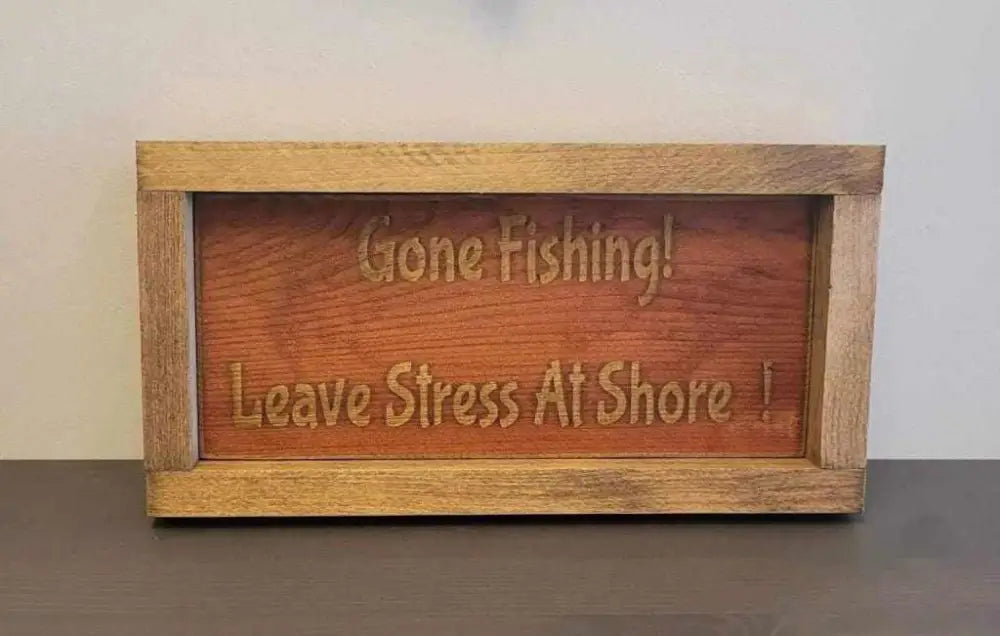 Laser engraved wood sign with "Gone Fishing! Leave Stress At Shore!" message, perfect for outdoor enthusiasts.