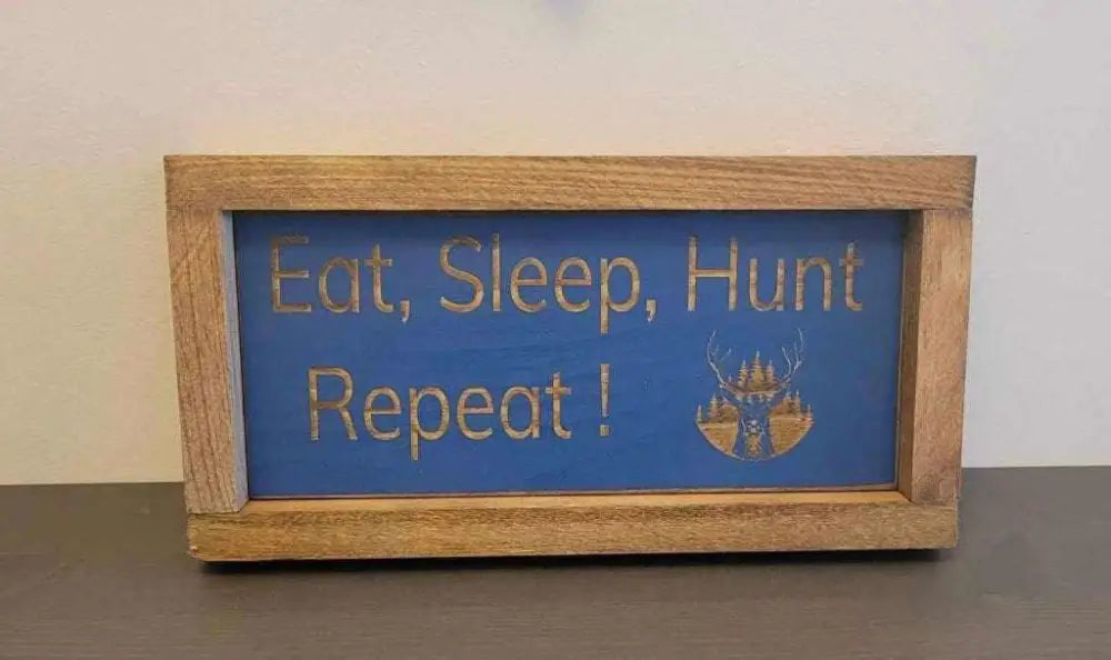 Laser engraved wood sign with "Eat, Sleep, Hunt, Repeat!" slogan, deer graphic, perfect for hunters and outdoor enthusiasts.