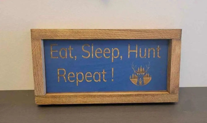 Laser engraved wood sign with "Eat, Sleep, Hunt, Repeat!" slogan, deer graphic, perfect for hunters and outdoor enthusiasts.