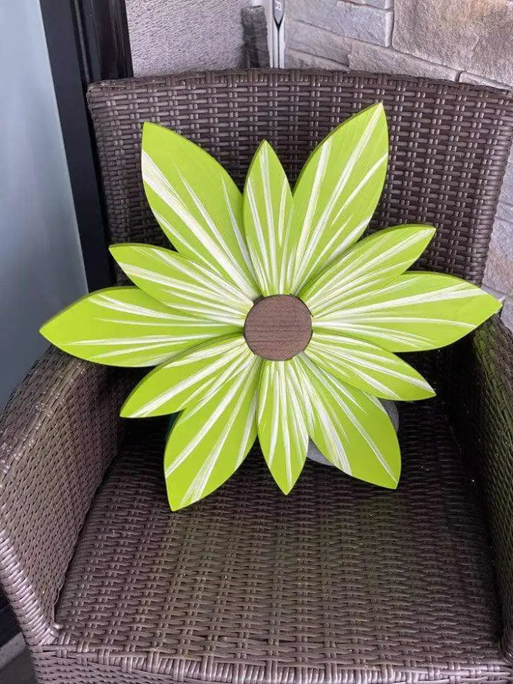 Handcrafted lime wood flower art made from pine on a woven chair.
