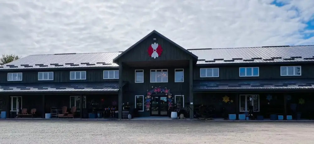 Large rustic building with a dark wooden exterior and a decorative wooden flower mounted above the entrance, showcasing the handcrafted wooden flower product.