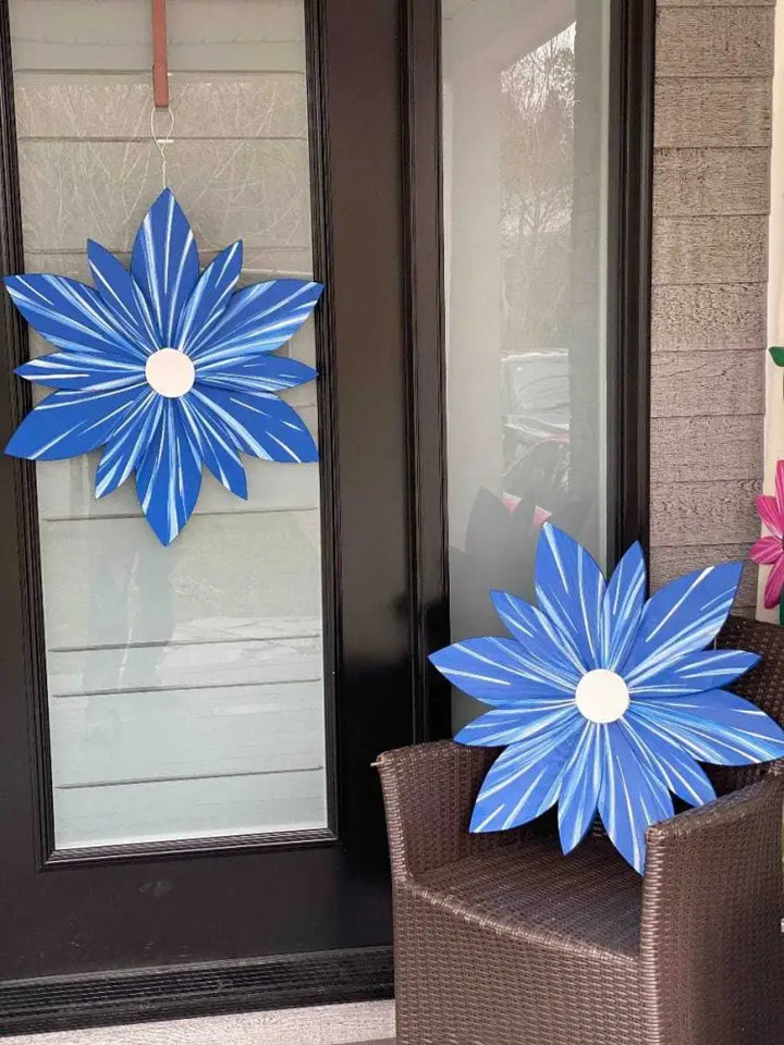Handcrafted Nova Scotia wooden flower art in blue, displayed on door and chair.