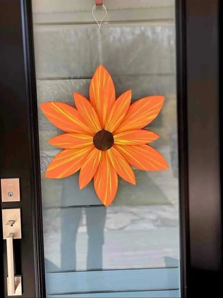 Handcrafted orange wood flower door decoration with yellow streaks, featuring durable paint and wire hanger.