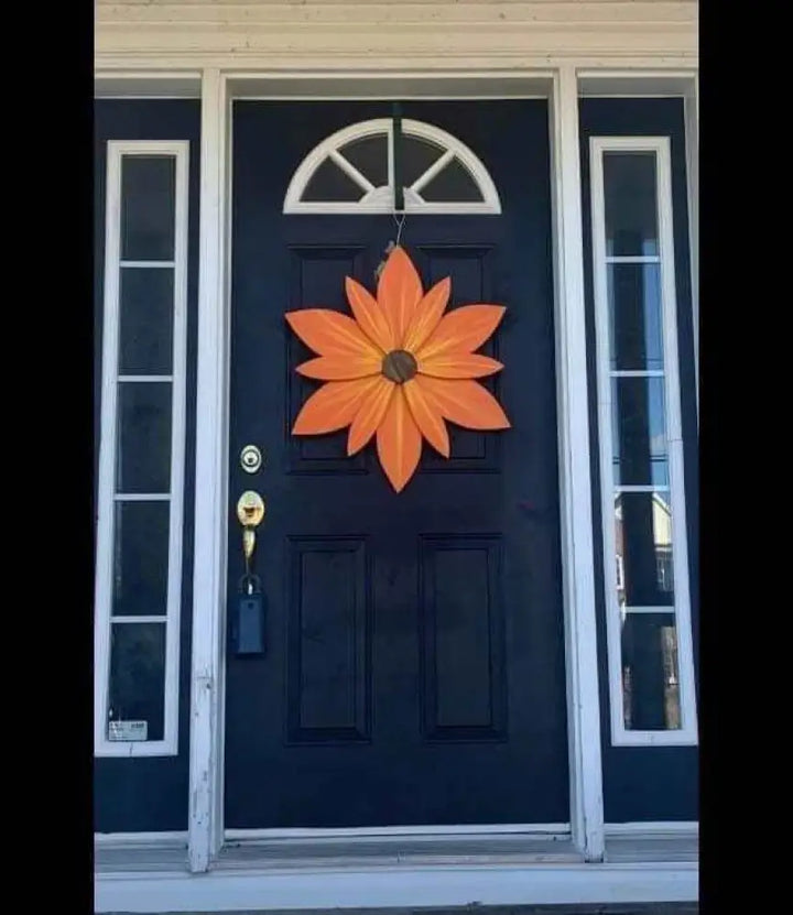 Handcrafted orange sunset wood flower door decoration with yellow streaks.