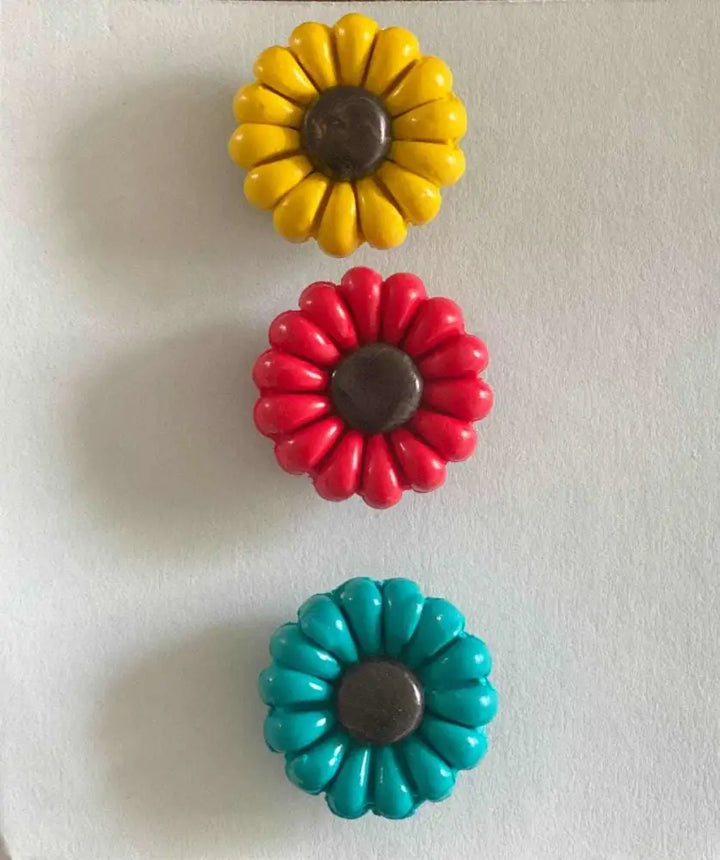 Polyclay Daisy Fridge Magnets in yellow, red, and blue supporting IWK Foundation.