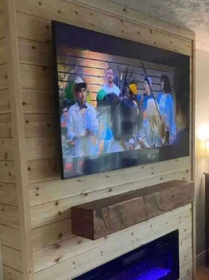 Sleek black TV on rustic wood mantel displaying vibrant costume imagery