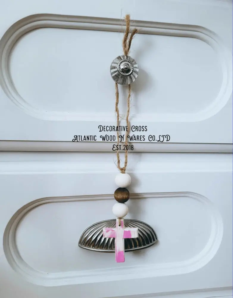 Rustic wooden bead and cross garland hanging on white panel door.