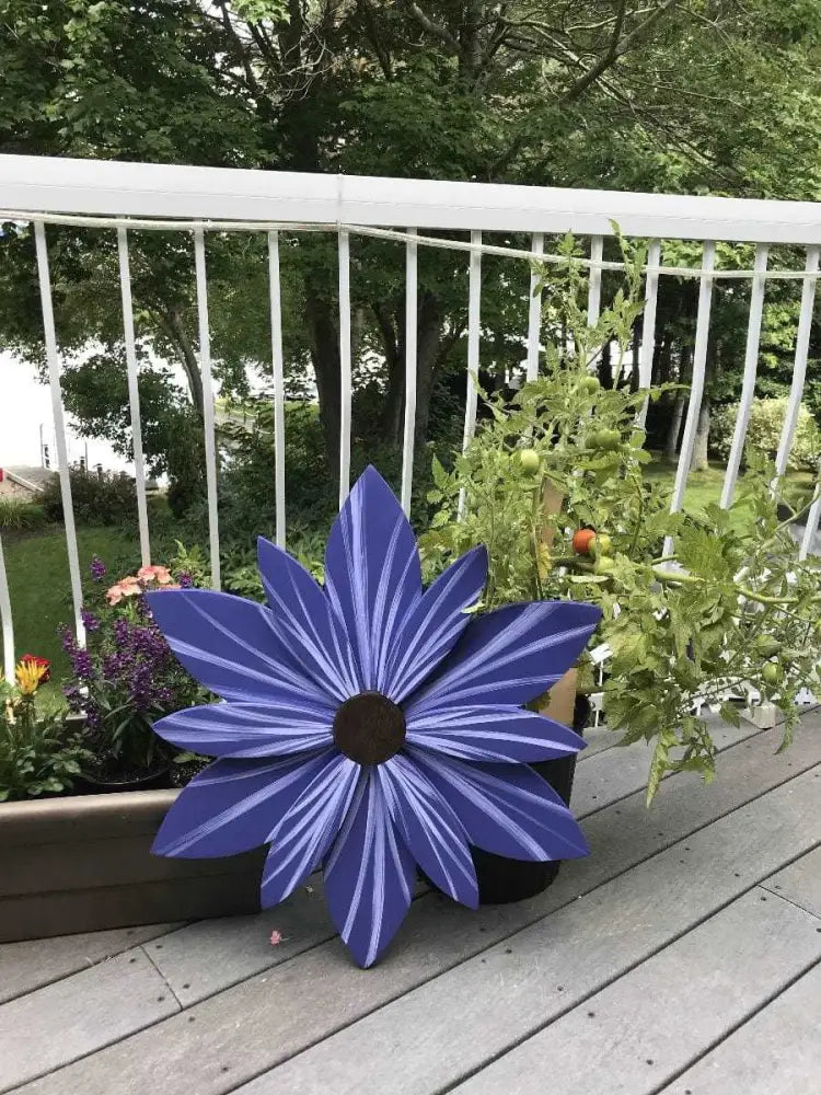 Scandinavian blue wooden flower art decoration on a patio.