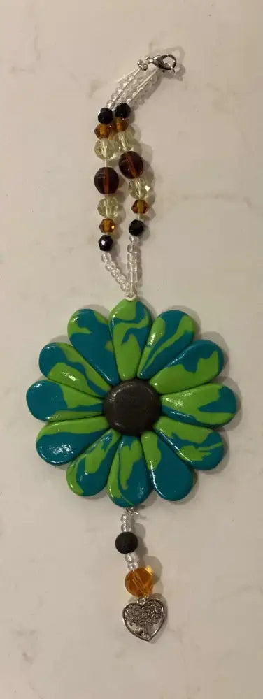 Handcrafted Sofia Daisy car window charm with polymer clay petals and beads supporting IWK Foundation.