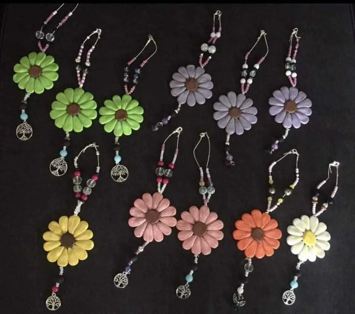 Colorful Sofia Daisy polymer clay car and window charms with beads and tree pendants, supporting the IWK Foundation.