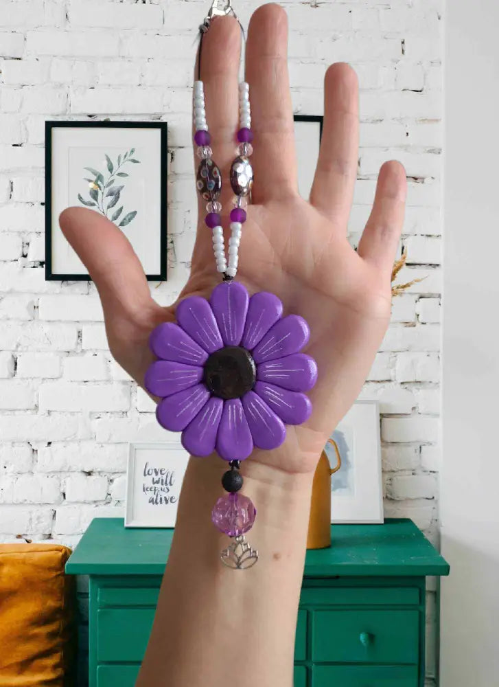 Purple Sofia Daisy Car/Window Charm with hand-sculpted petals, black lava bead, and glass accents; supports IWK Foundation.