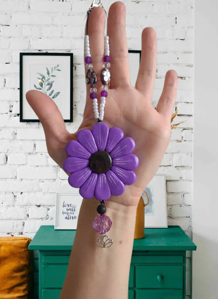 Purple Sofia Daisy Car/Window Charm with hand-sculpted petals, black lava bead, and glass accents; supports IWK Foundation.