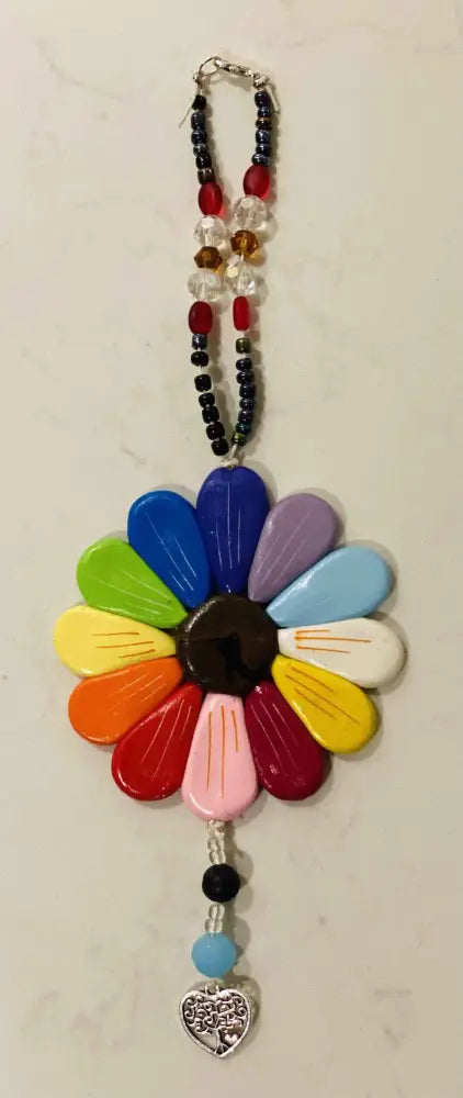 Colorful Sofia Daisy charm with polymer clay petals, glass beads, and black lava bead, supporting IWK Foundation.