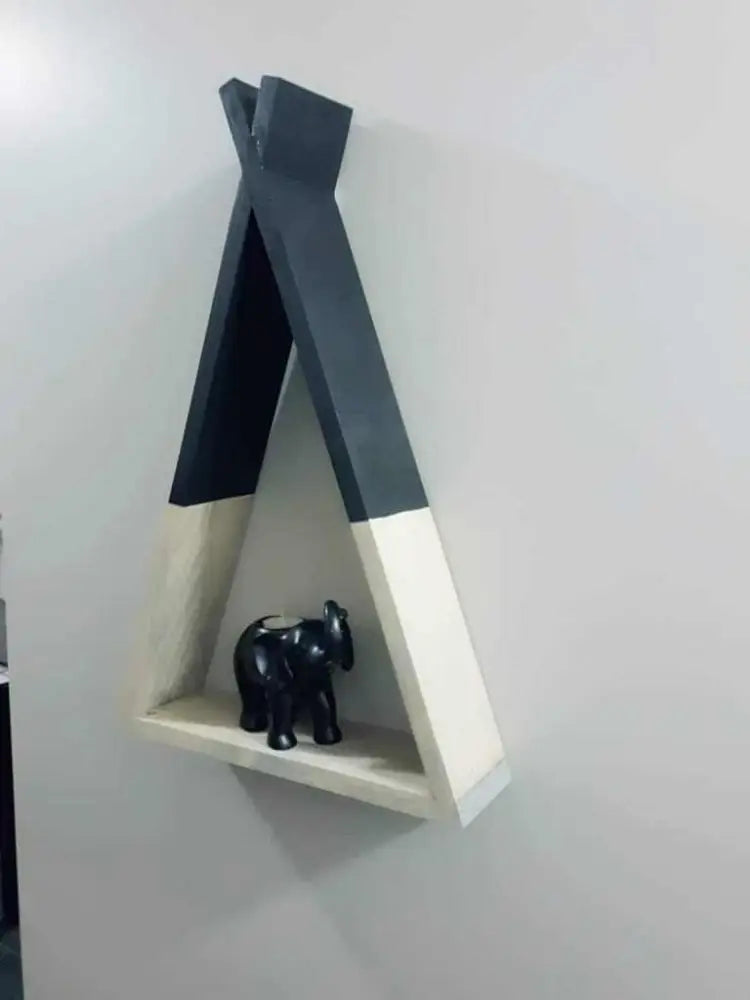 Handcrafted wooden teepee shelf on wall displaying small black figurine.