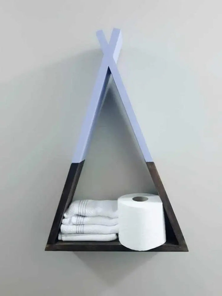 Handcrafted wooden teepee shelf displaying towels and a roll of toilet paper.